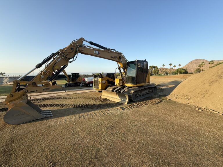 Yellow CAT excavator on graded dirt site next to earth materials, demonstrating and heavy equipment work.