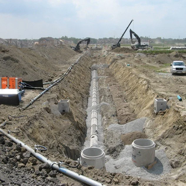 CAT excavators dig trenches for utility installation during SB 9 lot split site prep and drainage work.