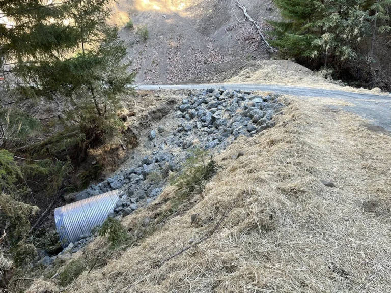 installation with riprap stone reinforcement along streambank during flood readiness preparation.